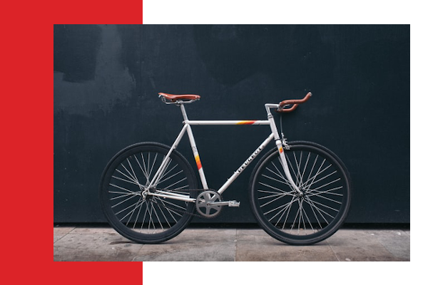 Bicycle leaning against black wall