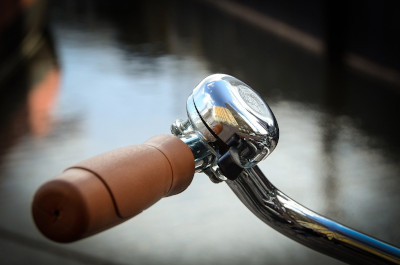 A bell on the handlebars of a bicycle