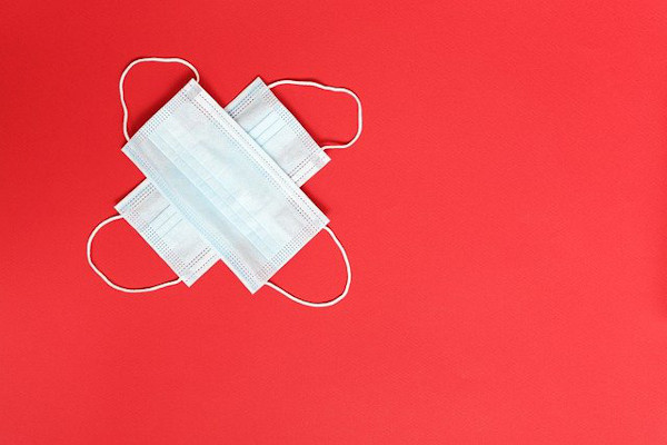 image of two masks on top of each other with a red background